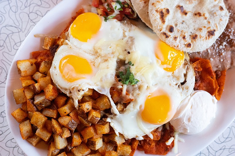 The St. Cecelia Plate, a spin on huevos rancheros, tops tortilla chips with ground beef simmered in a New Mexico red chile sauce, four sunny-side up eggs and cheddar cheese. - MABEL SUEN