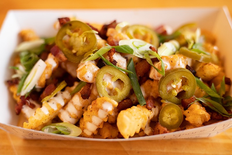 Garlic loaded fries with queso, bacon, pickled jalapeño, buttermilk-lime dressing and green onion. - MABEL SUEN
