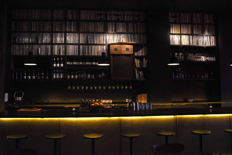 The bar is lined with shelves brimming with vinyl records. - TRENTON ALMGREN-DAVIS
