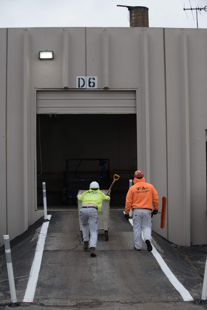 Workers roll a cart up a loading dock where bodies would enter the morgue. - TRENTON ALMGREN-DAVIS