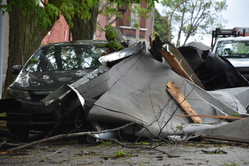 Debris from a roof landed against a car on Indiana Avenue during last night's storm. - DOYLE MURPHY