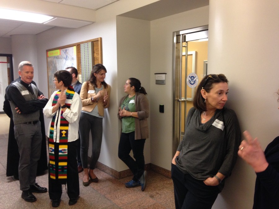 Nicole Cortés and Sara John (green shirt) talk outside the door of the ICE office in St. Louis. - DOYLE MURPHY