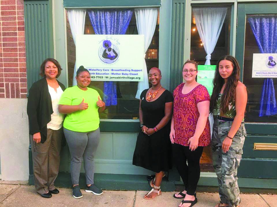 Tru Kellman, center, in front of Jamaa's first home with (from left) Yvonne Smith, Noni Rogers Boyd, Haley Manning and Madyson Winn.