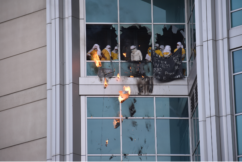Inmates drop flaming debris from the windows on February 6. - DOYLE MURPHY