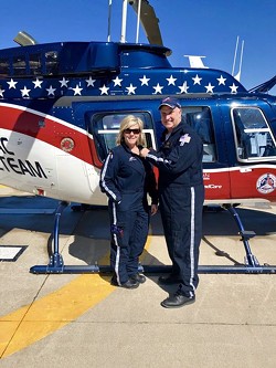 Tom Becker, a pilot with Air Evac Lifeteam in Missouri, awards flight wings in 2019 to Trisha Dutt, a nurse, after she had helped 50 patients on helicopter rescues. - HEATHER STEPHENS