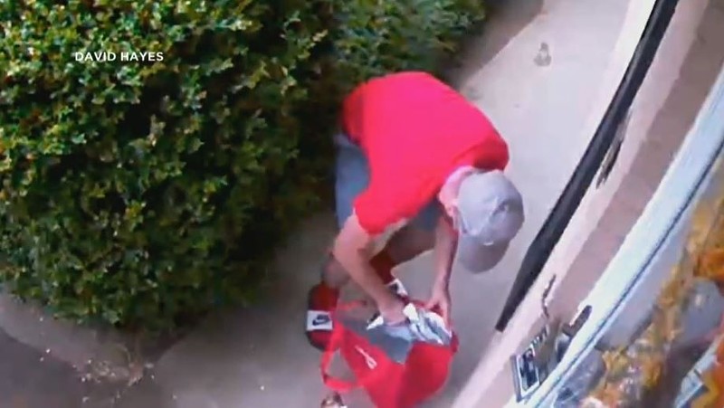 Security footage shows a porch pirate as he puts a white Amazon package into a DoorDash bag. - SCREENSHOT VIA KMOV