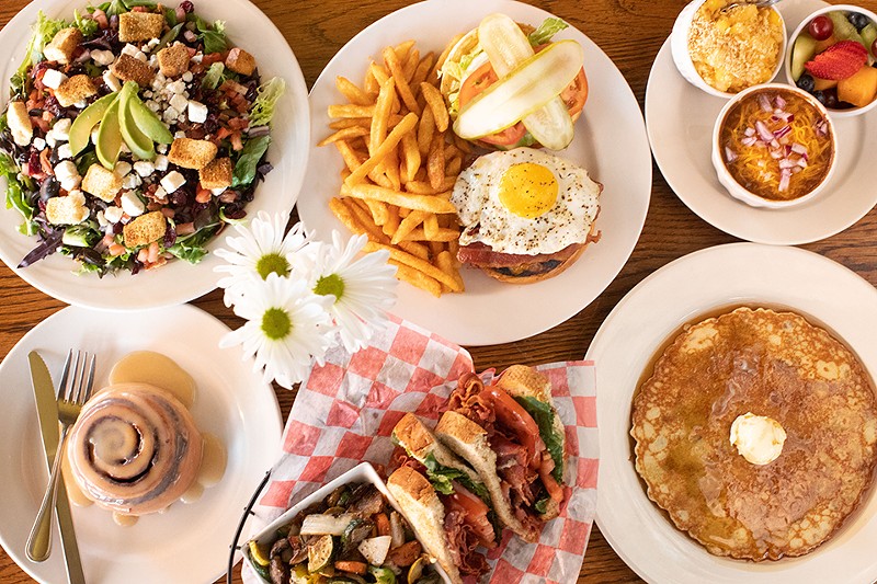 A selection of items from Have A Cow: Field Greens salad, The Whole Farm burger, sides, cinnamon roll, The Porker sandwich and pancakes. - MABEL SUEN