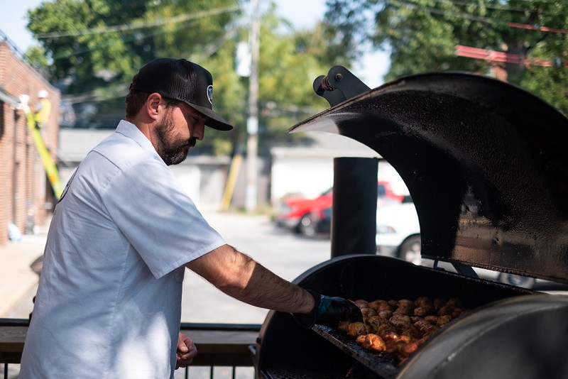 Chris Armstrong is thrilled to be tending to the smoker and grill at Navin's BBQ. - PHUONG BUI