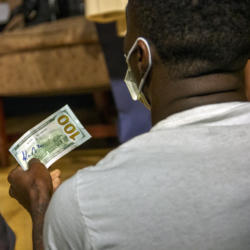 Terrion Watson holds up a $100 bill moments after Gardner signed and returned it to him. - DANNY WICENTOWSKI