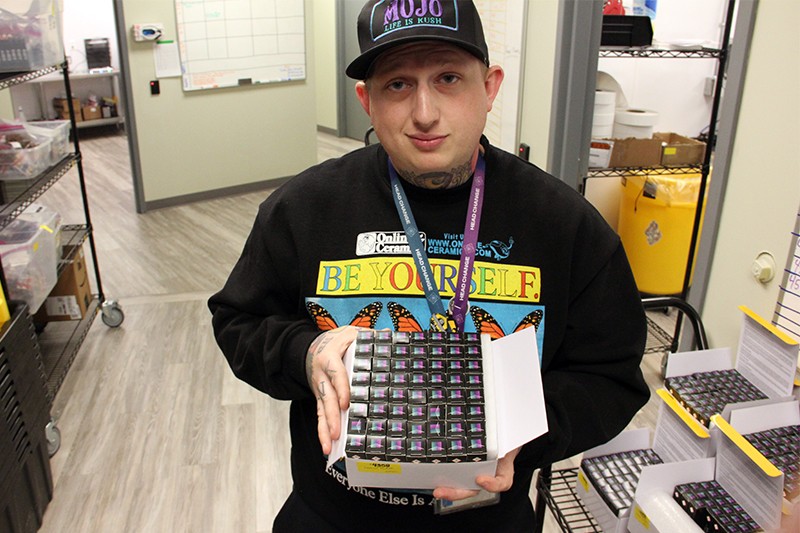 Cory Sanson, Curador co-founder, holds a box of "sauce carts" ready for delivery to dispensaries. - DANNY WICENTOWSKI