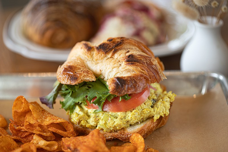 Gather's curried chicken salad sandwich combines tomatoes, greens, pickled red onions and cranberries on a croissant. - MABEL SUEN