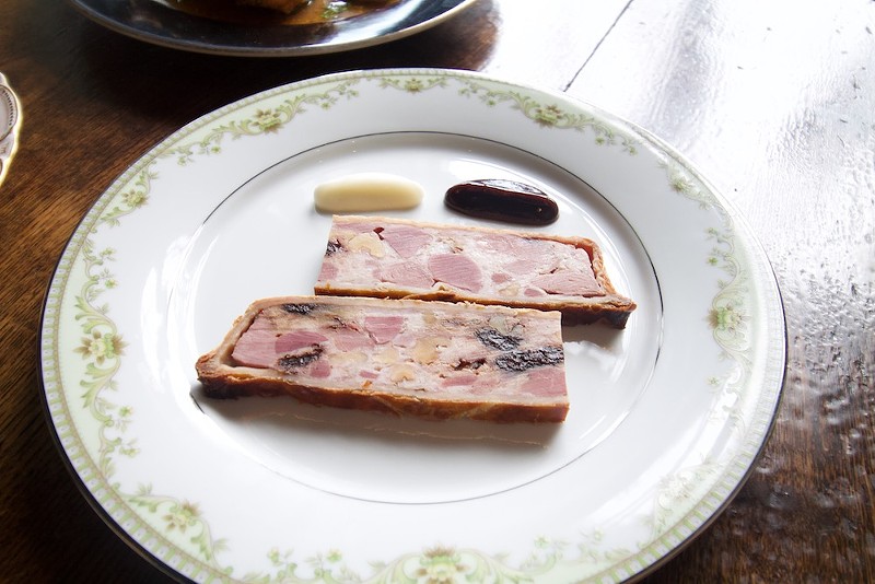 Bistro La Floraison's duck pate en croute is served with verjus braised bing cherries and sauce soubise. - Lulu Nix