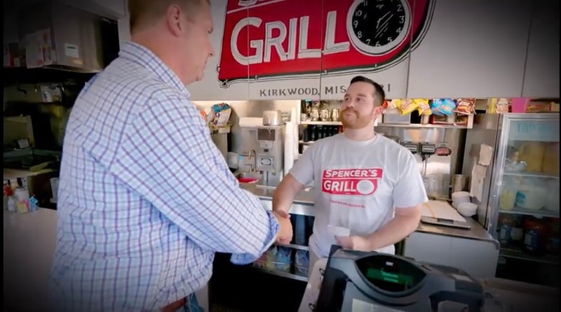 Eric Schmitt shakes hand with someone posing as a Spencer's Grill employee. - Screenshot via YouTube
