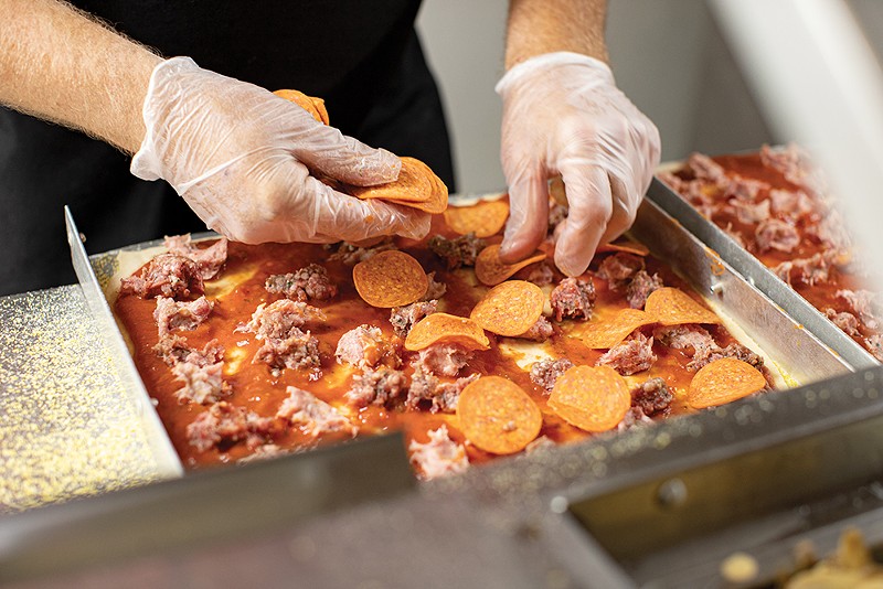 The meat lovers pizza gets assembled in the Monte Bello kitchen.