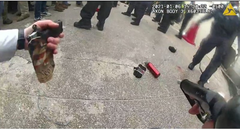 A U.S. Capitol officer handles Jerod Bargar's alleged gun.