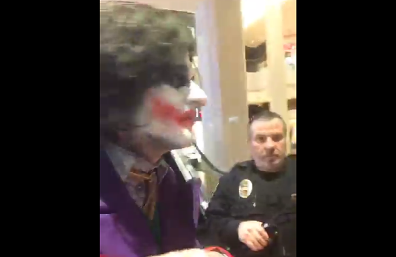 In this screenshot from a now-deleted livestream, authorities confront Jeremy Garnier for making threats while dressed as the Joker.