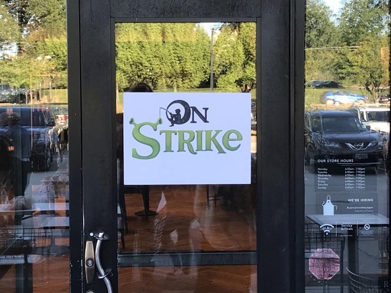 A sign posted on a door that reads "On Strike."