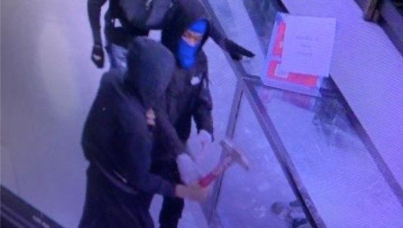A still from surveillance video showing a gun store robbery in progress.