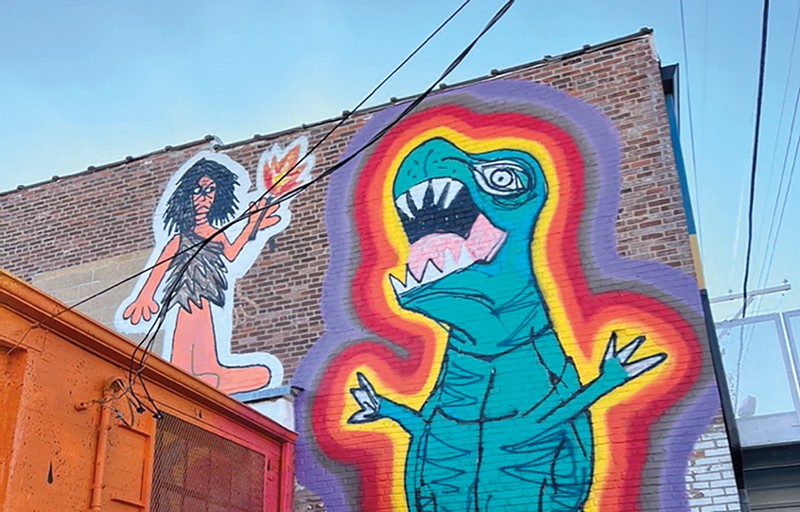 Mural of a dinosaur and a girl.