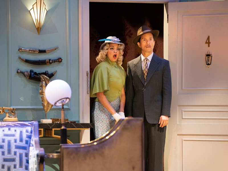 A woman and a man, dressed in 1930s attire, stand in a doorway, staring in disbelief in a scene from Noel Coward’s ‘Private Lives,’ at The Rep in St. Louis.