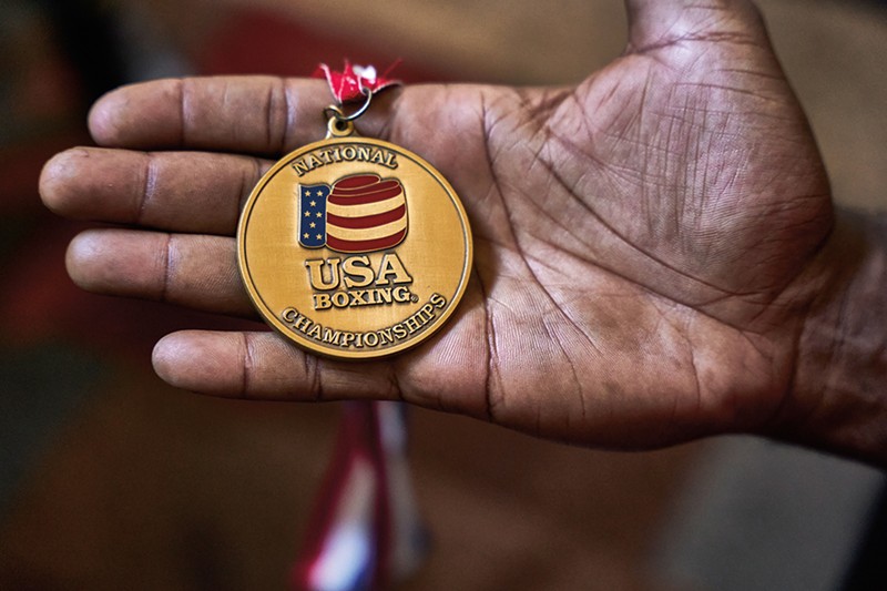 A hand holds a medal.