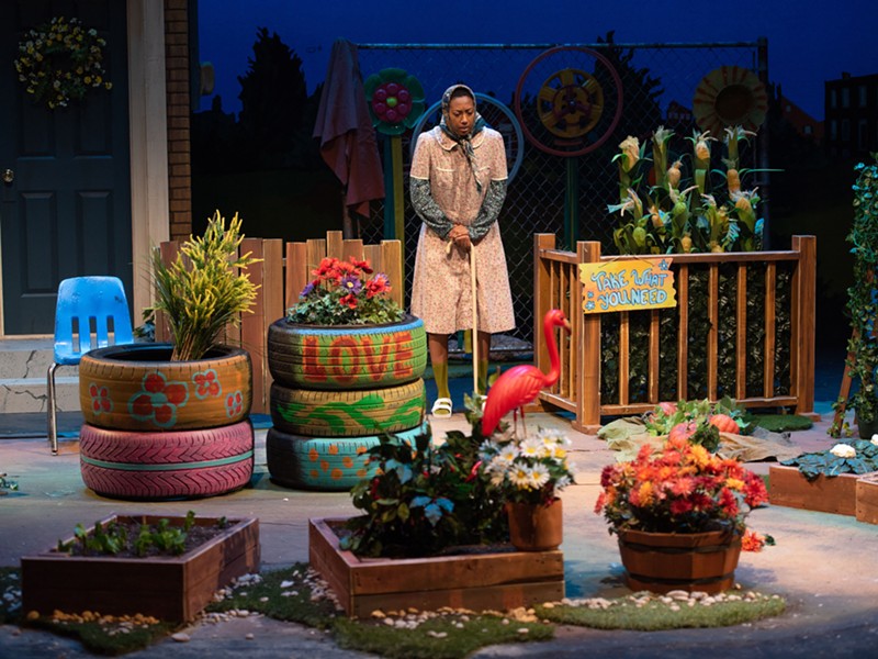 An older woman looks over a garden that’s been planted in what was a vacant lot filled with garbage in a scene from the play ‘Seedfolks.’