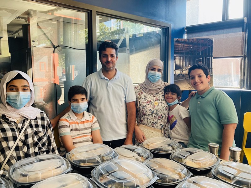 Cooks from Dubai standing in front of their Supper Club meals.