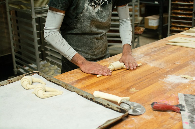 A person forms dough.