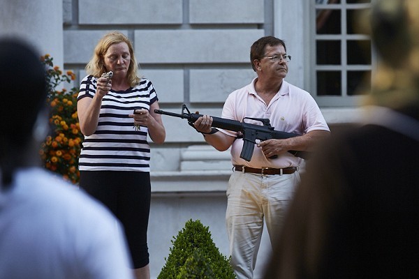Mark and Patricia McCloskey hold guns outside their home.