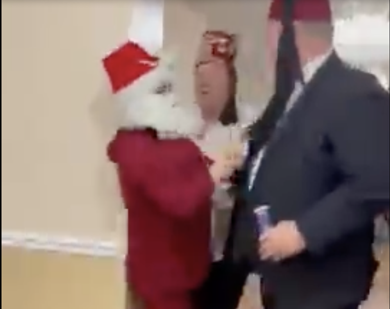 Protester Sasha Monik, left, dressed as Santa, can be seen in a video filmed by a fellow protester getting shoved by a Shriner. - VIA KYLE MAYBERRY VIDEO