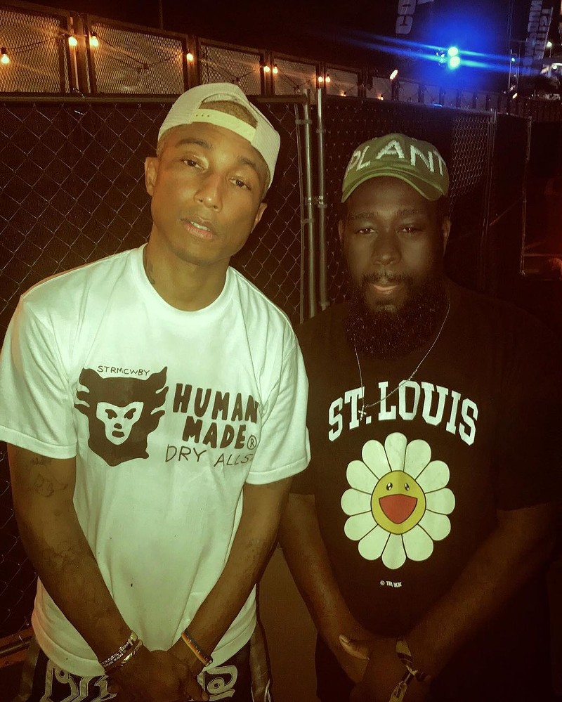 Pharrell and Jas Bell, who is wearing a "St. Louis" shirt, post for a picture together.