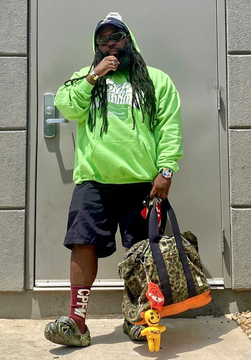 Jas Bell poses with a green hoodie that reads "Still Learning."