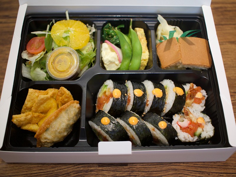 The spicy salmon bento box includes a roll and a selection of side dishes.