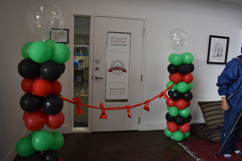 The Afghan Community Center office behind red tape and green, black and red balloons.