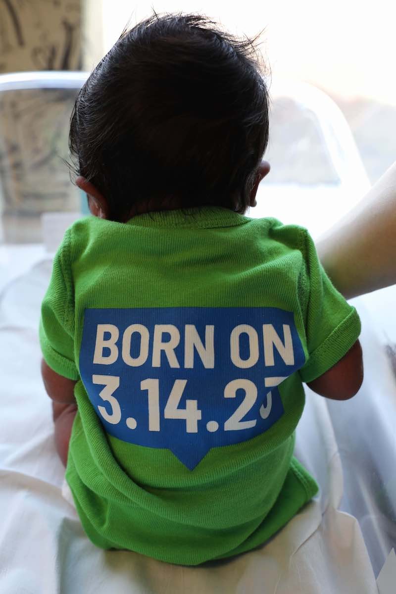The backs of the 314 Day onesies.