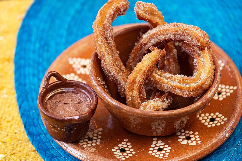 The churros are served with chocolate.