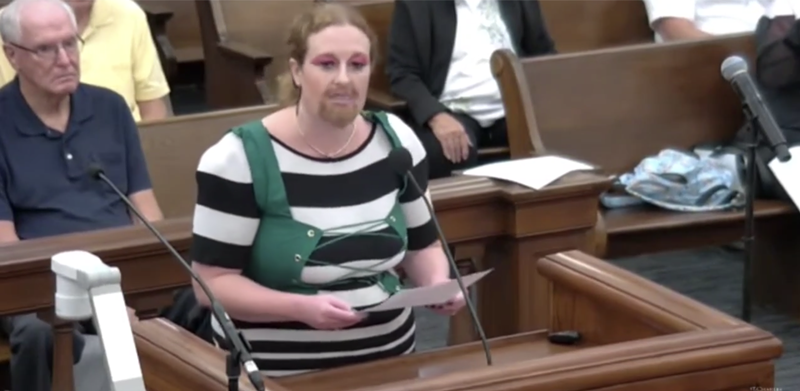 At a previous library board meeting, Rachel Homolak indulged in gender-nonconforming librarian cosplay, claiming she was wearing a "replica" of the offending attire in order to show its dangers to children. It was ... odd. - SCREENSHOT VIA stltoday.com