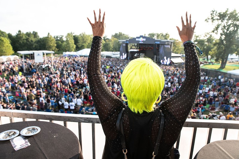 A fan watches Evolution Festival's debut in Forest Park from the VIP area. - Max Bouvatte