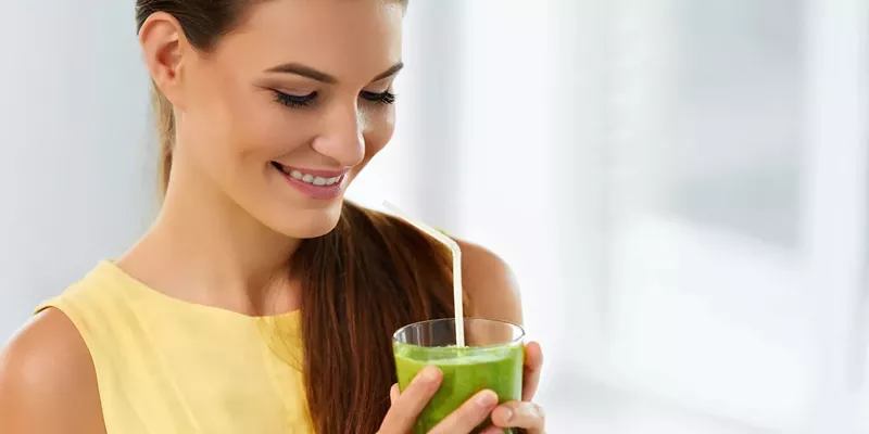 Woman drinking a green liquid detox drink to cleanse THC from her system.