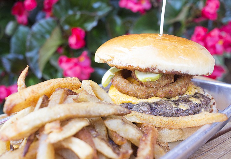 The "Das Bevo Burger" includes a half-pound patty, pub cheese, pretzel-breaded onion rings and pickles. - PHOTO BY MABEL SUEN
