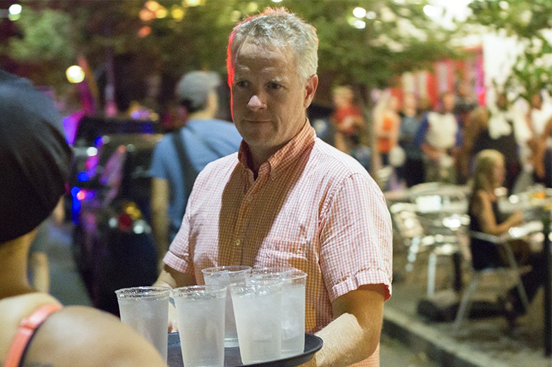 Pi Pizzeria owner Chris Sommers distributing cups of water to protesters Friday night. - PHOTO BY DANNY WICENTOWSKI