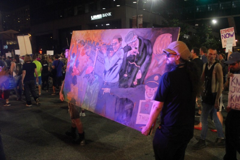 Protesters carried a painting inspired by the Jason Stockley case. - PHOTO BY DOYLE MURPHY