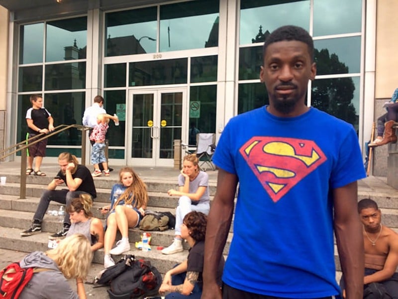 Bruce Franks stands outside the Justice Center downtown after being released Wednesday afternoon. A group of forty or so people continued to wait for the rest of the protesters to be released. - Photo by Daniel Hill