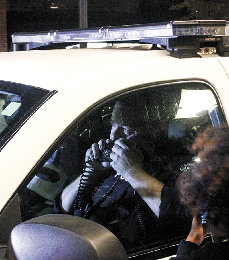 Sgt. Brian Rossomanno speaks into his radio as protesters 'kettle' him on Sept. 28 in downtown St. Louis. - DOYLE MURPHY