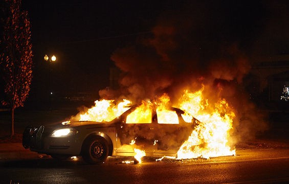 A police car burns.