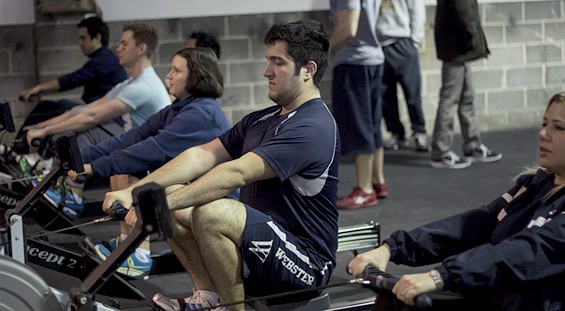 Before working out, teammates get their blood pumping on the rowing machine.