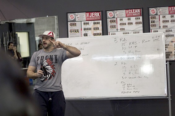 Mike Walerius, co-owner of Crossfit26 gym, explains the exercises of the day to the team.