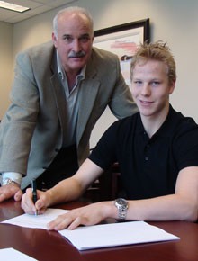 Eller signing his first pro contract as JD looks on. - BLUES.NHL.COM