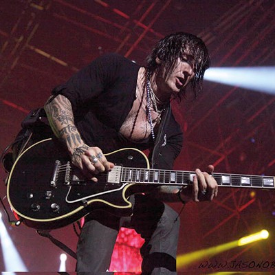 Richard Fortus plays guitar on stage.