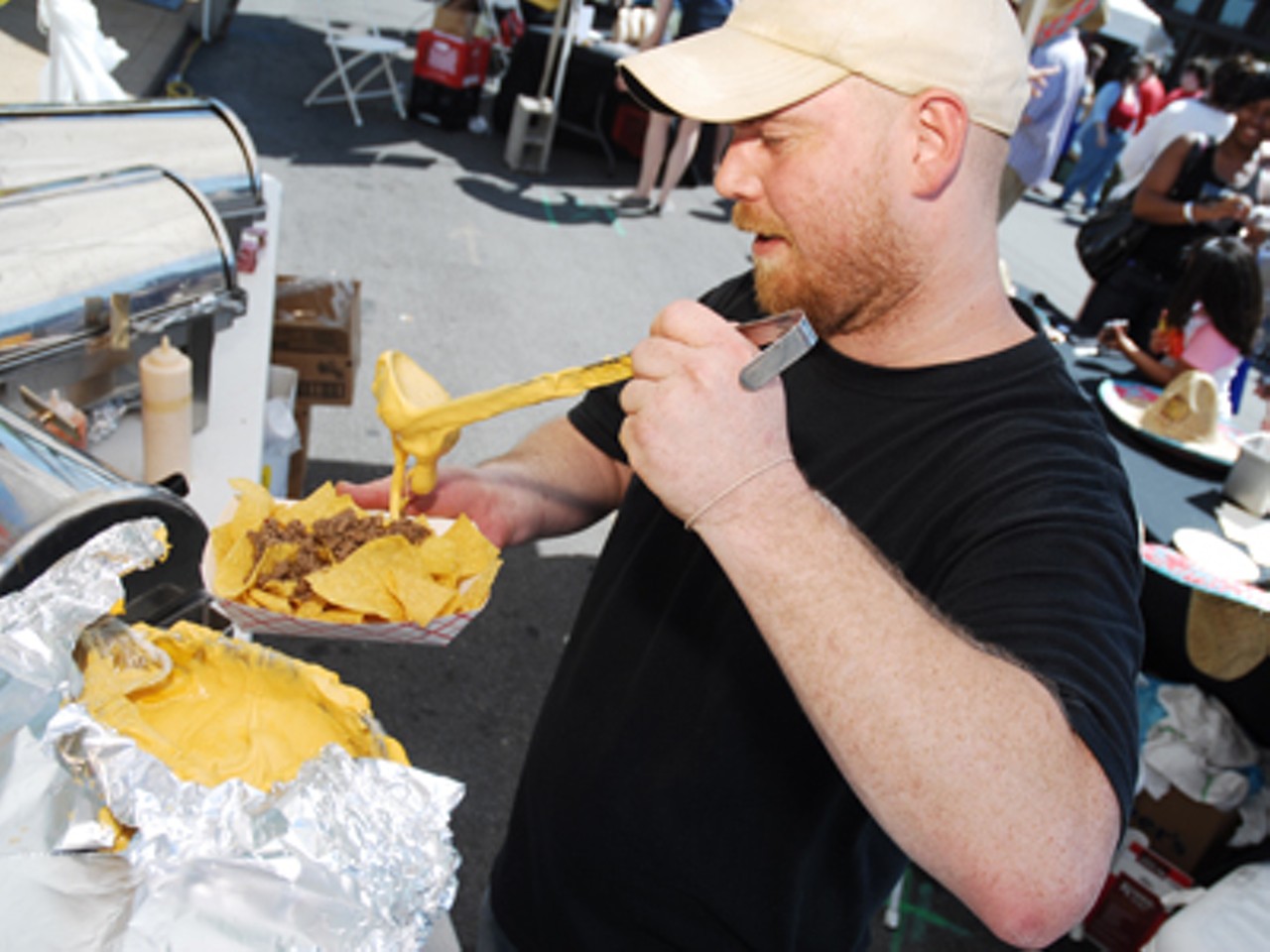 El Scorcho owner Mark Lucas pours the three cheese blend onto an order of nachos.
